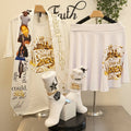 White sweatshirt with gold text and graphics on a stand, with a white skirt and socks displayed nearby.